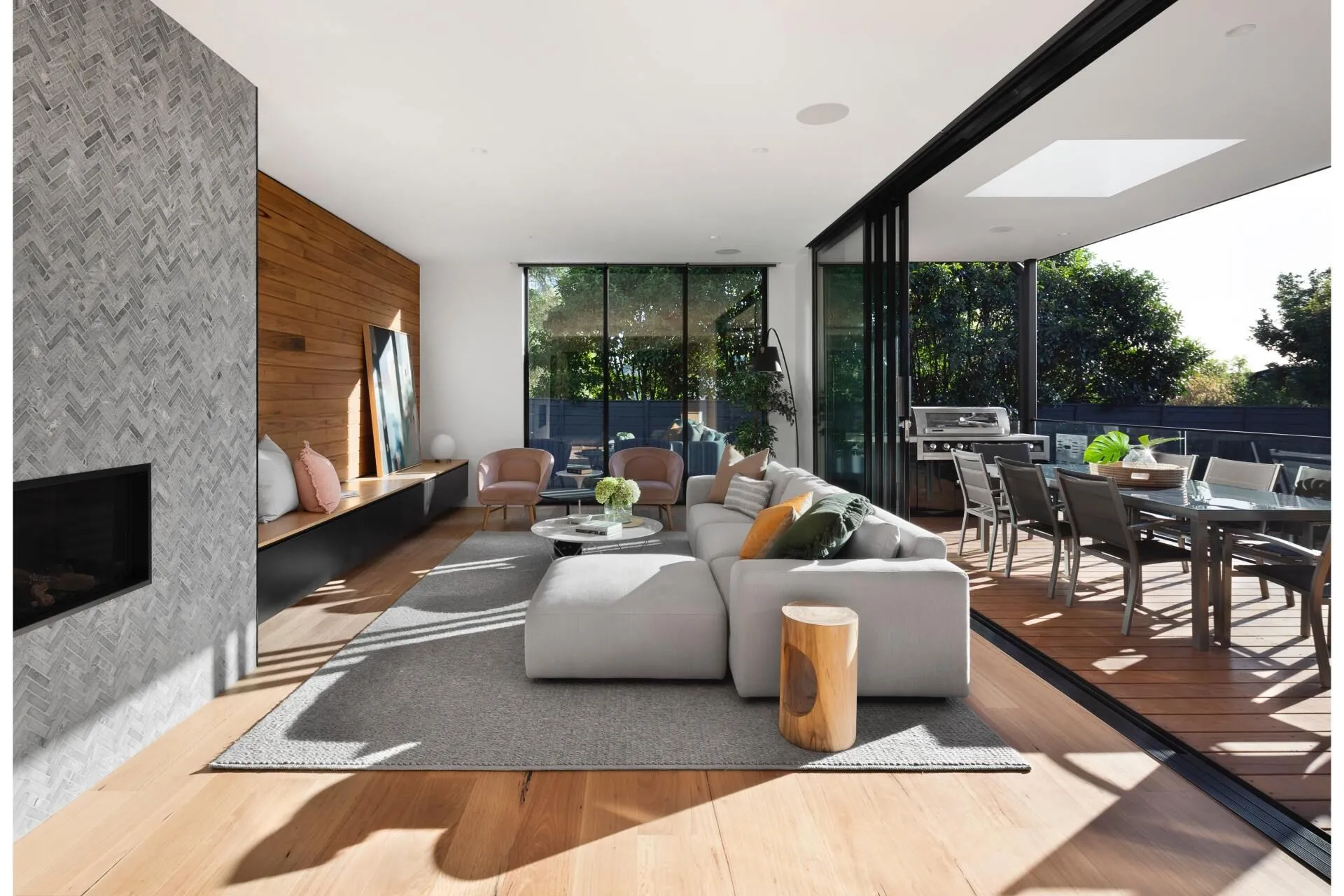 Modern living room with open sliding door to outdoor dining area.